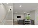 Bright living room with stairs, modern furnishings, large windows, and hardwood floors at 72 Aurora Ave, Ponce Inlet, FL 32127