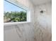 Bright shower with white marble tile and window at 72 Aurora Ave, Ponce Inlet, FL 32127