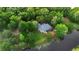 A stunning aerial view of the property, nestled in a lush landscape and backing onto a tranquil pond at 725 E New York Ave, Orange City, FL 32763