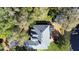 Aerial view of the house highlighting the spacious backyard, pond, deck, and mature landscaping at 725 E New York Ave, Orange City, FL 32763