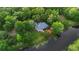 A beautiful aerial view showcases the home, surrounded by lush greenery and situated next to a serene pond at 725 E New York Ave, Orange City, FL 32763