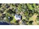 Aerial view showcasing the home's backyard, pond, deck, and lush surrounding greenery at 725 E New York Ave, Orange City, FL 32763