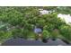 Aerial view of property situated beside a calm pond and surrounded by mature trees, offering privacy and natural beauty at 725 E New York Ave, Orange City, FL 32763
