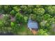 Picturesque aerial view of a home surrounded by lush greenery, a pond, and a serene landscape at 725 E New York Ave, Orange City, FL 32763