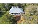 A high aerial view of the house showing the deck, screened in patio, and the wooded back yard at 725 E New York Ave, Orange City, FL 32763