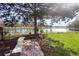 Inviting backyard view features a patio with bench and serene water views and mature landscaping at 725 E New York Ave, Orange City, FL 32763