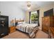 Cozy bedroom featuring a comfortable bed, a large window, and stylish furnishings for relaxation and rest at 725 E New York Ave, Orange City, FL 32763