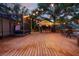 Expansive wooden deck features screened-in porch, outdoor TV, seating and bar for entertaining at 725 E New York Ave, Orange City, FL 32763