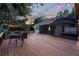 Spacious wooden deck with outdoor seating and strung bistro lights provides an inviting space for evening relaxation at 725 E New York Ave, Orange City, FL 32763
