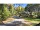 Long driveway leading to a beautiful home surrounded by lush greenery and mature trees at 725 E New York Ave, Orange City, FL 32763