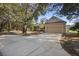 Inviting home featuring a lush lawn, mature trees, and a spacious driveway leading to a two-car garage at 725 E New York Ave, Orange City, FL 32763