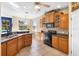 Well-lit kitchen with dark appliances, wooden cabinets and a breakfast bar at 725 E New York Ave, Orange City, FL 32763