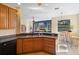 Open kitchen offers a view of the game room, bar seating, stainless steel sink and brown wood cabinets at 725 E New York Ave, Orange City, FL 32763