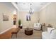 Neutral living room featuring a chandelier, soft lighting, and comfortable white chairs at 725 E New York Ave, Orange City, FL 32763