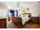 This beautiful main bedroom has a decorative dresser and a large bed facing a window at 725 E New York Ave, Orange City, FL 32763