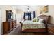 This beautiful main bedroom has a decorative dresser and a large bed facing a window at 725 E New York Ave, Orange City, FL 32763