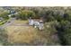 Wide aerial perspective showing the home, its outbuildings, surrounding trees, and proximity to nearby road at 753 Glenwood Rd, Deland, FL 32720