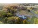 Aerial view of the property featuring lush tree coverage, the main house, and storage buildings at 753 Glenwood Rd, Deland, FL 32720