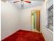 Small empty bedroom with red carpet and a view into the bathroom through a doorway at 753 Glenwood Rd, Deland, FL 32720
