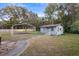 Exterior view of a single-story home with a metal carport and mature trees at 753 Glenwood Rd, Deland, FL 32720