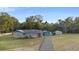 Charming one-story home with brick and siding, featuring a long driveway and detached garage in a lush setting at 753 Glenwood Rd, Deland, FL 32720