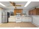 Bright kitchen featuring wooden cabinets, white appliances, and tile flooring at 753 Glenwood Rd, Deland, FL 32720