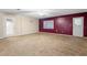 Large living room with beige carpet, ceiling fan, and a contrasting accent wall, filled with natural light at 753 Glenwood Rd, Deland, FL 32720