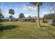 Expansive backyard featuring lush lawn, mature trees, and screened porch at 825 Wells Dr, South Daytona, FL 32119