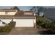 Attached garage with a white door on a two-story home with car parked on driveway at 1101 Monticello Ln # 3, Port Orange, FL 32129