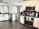 Modern kitchen featuring stainless steel appliances, stone countertops, and wood-look tile flooring at 112 Muscovy Ct, Daytona Beach, FL 32119