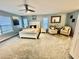 Large main bedroom featuring neutral carpet, ceiling fan, accent chairs, and lots of natural light at 112 Muscovy Ct, Daytona Beach, FL 32119