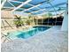 Relax by the private screened-in pool featuring brick pavers, lush landscaping, and a serene waterfall at 112 Muscovy Ct, Daytona Beach, FL 32119