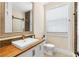 Modern bathroom with a wood countertop vanity, stone accent wall, and sliding glass shower door at 12736 Lake Ridge Cir, Clermont, FL 34711