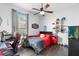 Clean bedroom featuring a window, ceiling fan, red and black bedding, and modern decor at 12736 Lake Ridge Cir, Clermont, FL 34711
