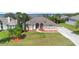 Beautiful single-story home with a well-manicured lawn and stone walkway to the front door at 12736 Lake Ridge Cir, Clermont, FL 34711