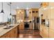 Well-lit kitchen with wooden cabinets, granite countertops, stainless steel appliances, and wood flooring at 12736 Lake Ridge Cir, Clermont, FL 34711