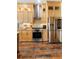 Modern kitchen with wooden cabinets, stainless steel appliances, granite countertops, and rustic wood flooring at 12736 Lake Ridge Cir, Clermont, FL 34711