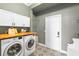 Well-lit laundry room featuring a wood countertop, cabinets, and a modern washer and dryer at 12736 Lake Ridge Cir, Clermont, FL 34711