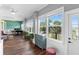 Bright living room with hardwood floors, plants, and ample natural light from large windows overlooking the yard at 12736 Lake Ridge Cir, Clermont, FL 34711