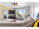 Inviting living room features a ceiling fan, a large bay window, and comfortable seating on hardwood flooring at 12736 Lake Ridge Cir, Clermont, FL 34711