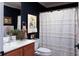 This bathroom features navy walls, framed art, and a white, patterned shower curtain at 12841 Se 97Th Terrace Rd, Summerfield, FL 34491