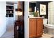 View of the bathroom from the hallway featuring wood cabinets and navy walls at 12841 Se 97Th Terrace Rd, Summerfield, FL 34491
