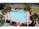 Large community pool with surrounding lounge chairs and landscaped grounds and palm trees at 12841 Se 97Th Terrace Rd, Summerfield, FL 34491