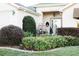 Beautiful front yard landscaping with flowering plants and manicured shrubs leading to the front door at 12841 Se 97Th Terrace Rd, Summerfield, FL 34491