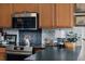 Modern kitchen with stainless steel appliances, dark countertop and decorative accents at 12841 Se 97Th Terrace Rd, Summerfield, FL 34491