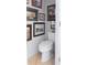 Small powder room features framed art and a white toilet at 12841 Se 97Th Terrace Rd, Summerfield, FL 34491