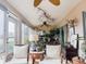Bright sunroom with plenty of seating and windows showcasing the greenery of the outdoors at 12841 Se 97Th Terrace Rd, Summerfield, FL 34491