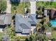Aerial top-down view of the house shows a well manicured lawn, beautiful trees, and a pool at 13 Sandcastle Dr, Ormond Beach, FL 32176