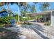 Well-maintained backyard with an outdoor kitchen, lush landscaping, covered patio, and stone features for outdoor enjoyment at 13 Sandcastle Dr, Ormond Beach, FL 32176