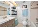 Well-lit bathroom featuring a vanity with storage, a toilet, and decorative shelving at 13 Sandcastle Dr, Ormond Beach, FL 32176